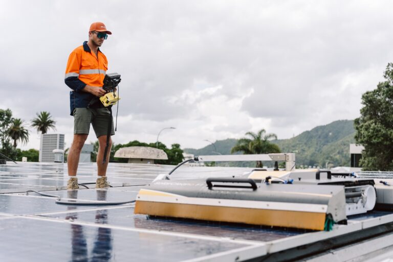 Eco Shine Solar technician operating the SolarCleano F1 robot on a commercial rooftop solar array