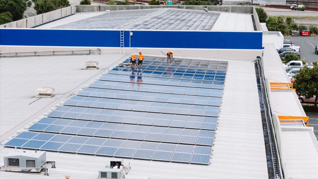 Eco Shine Solar crew cleaning a large commercial rooftop solar array, seen from a drone
