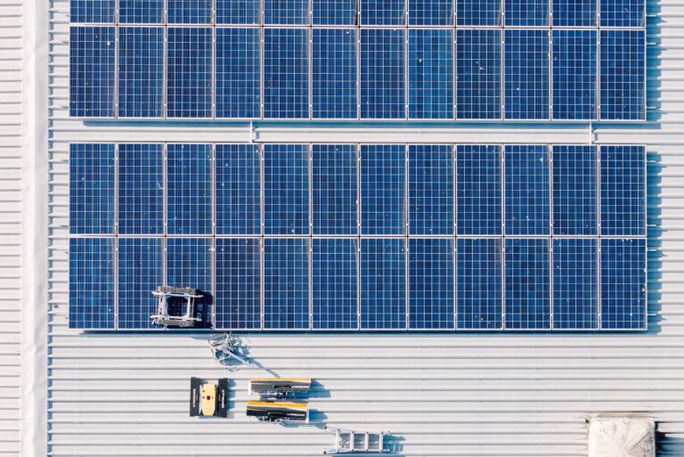 Drone view of a commercial rooftop solar array during a professional clean