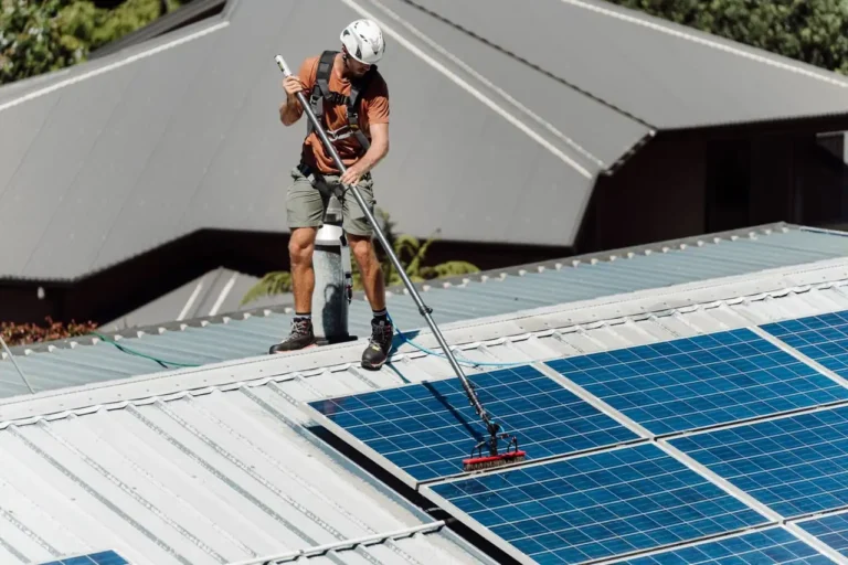 An Eco Shine Solar technician cleaning solar panels on a house roof